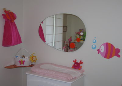 espejo ovalado infantil con detalles de color. Dormitorio.