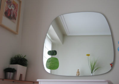 espejo decorativo con forma y detalles de color. Dormitorio.