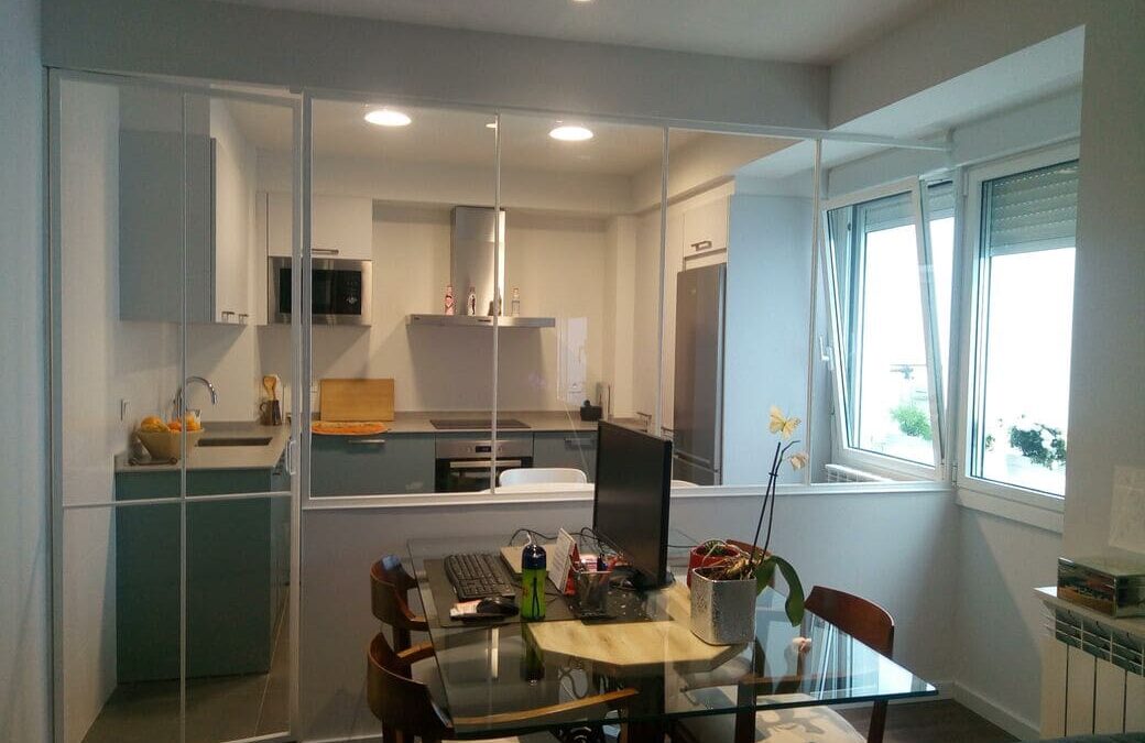 Cerramiento para cocina con panel fijo y puerta abatible.