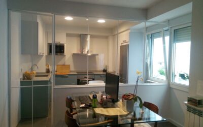 Cerramiento para cocina con panel fijo y puerta abatible.