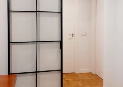 Puerta corredera colocada ente salón y zona de habitaciones, colocada en superficie sobre pared. Trabajo rápido y sin obras